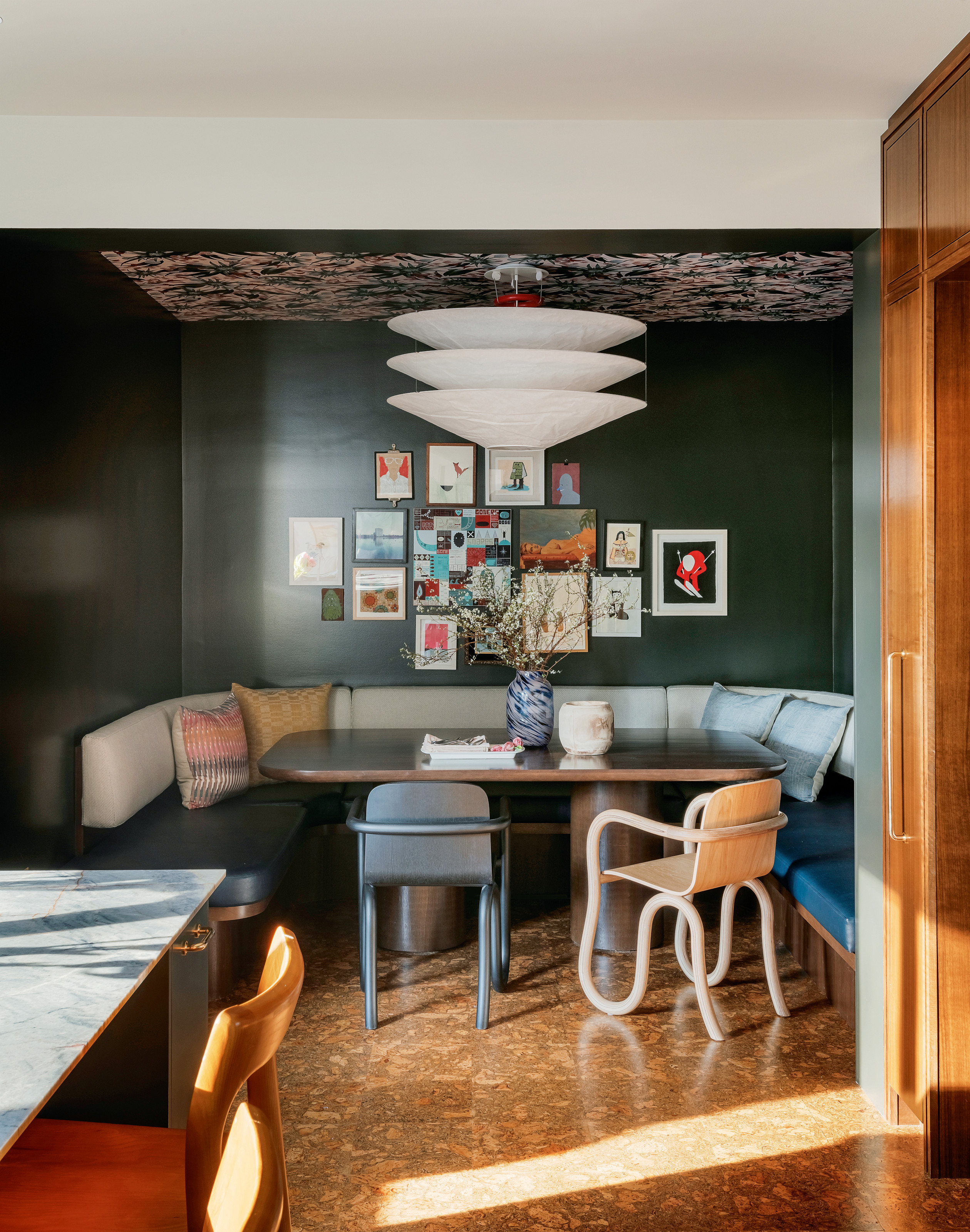 Blue breakfast nook with banquette seating, mismatched chairs and chandelier light