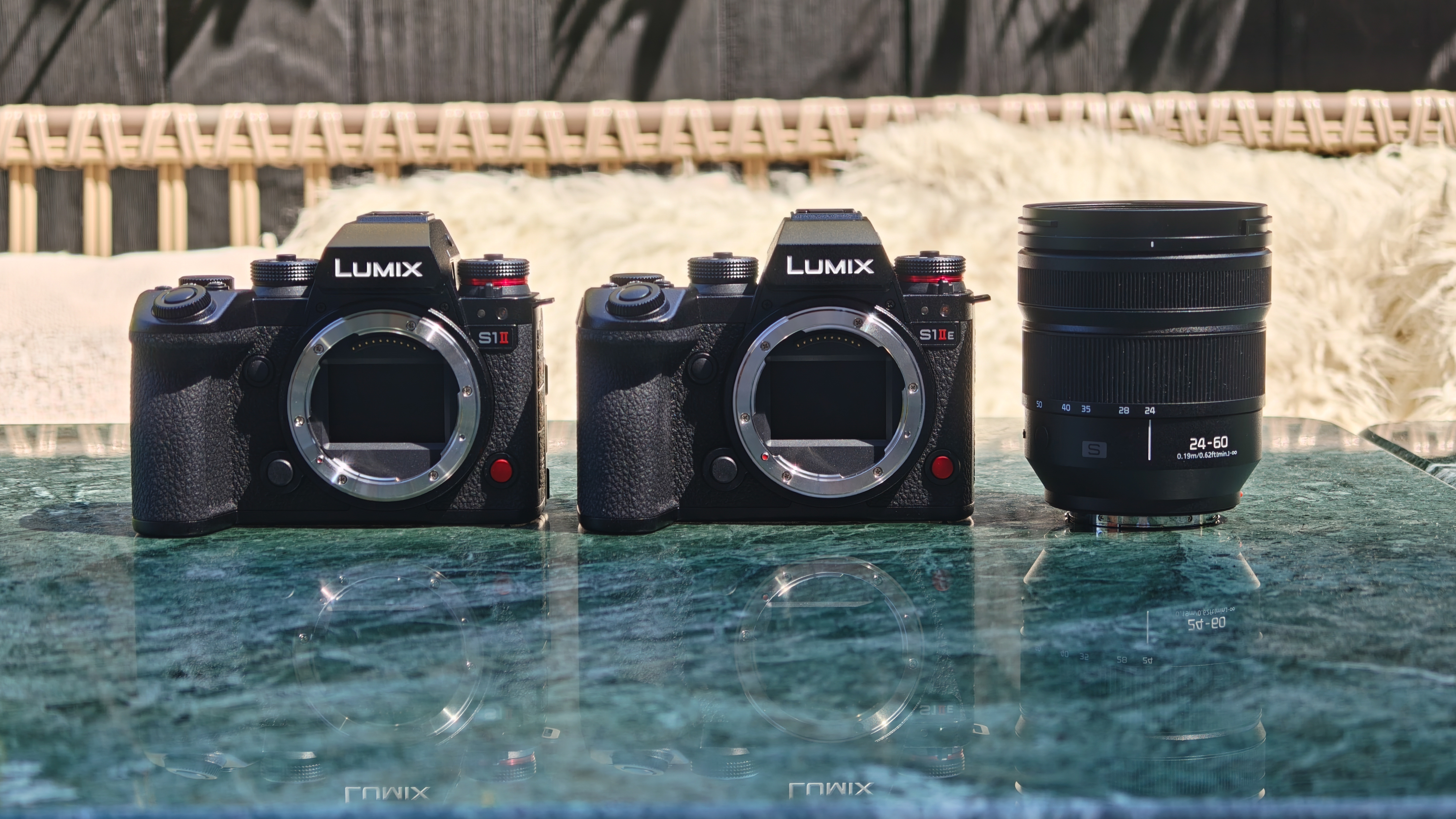 Panasonic Lumix S1II and S1IIE cameras alongside the Panasonic Lumix S 24-60mm f/2.8 lens on a marble table