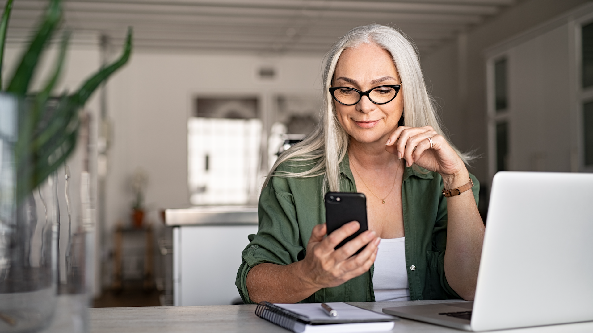 Woman looking at phone at desk