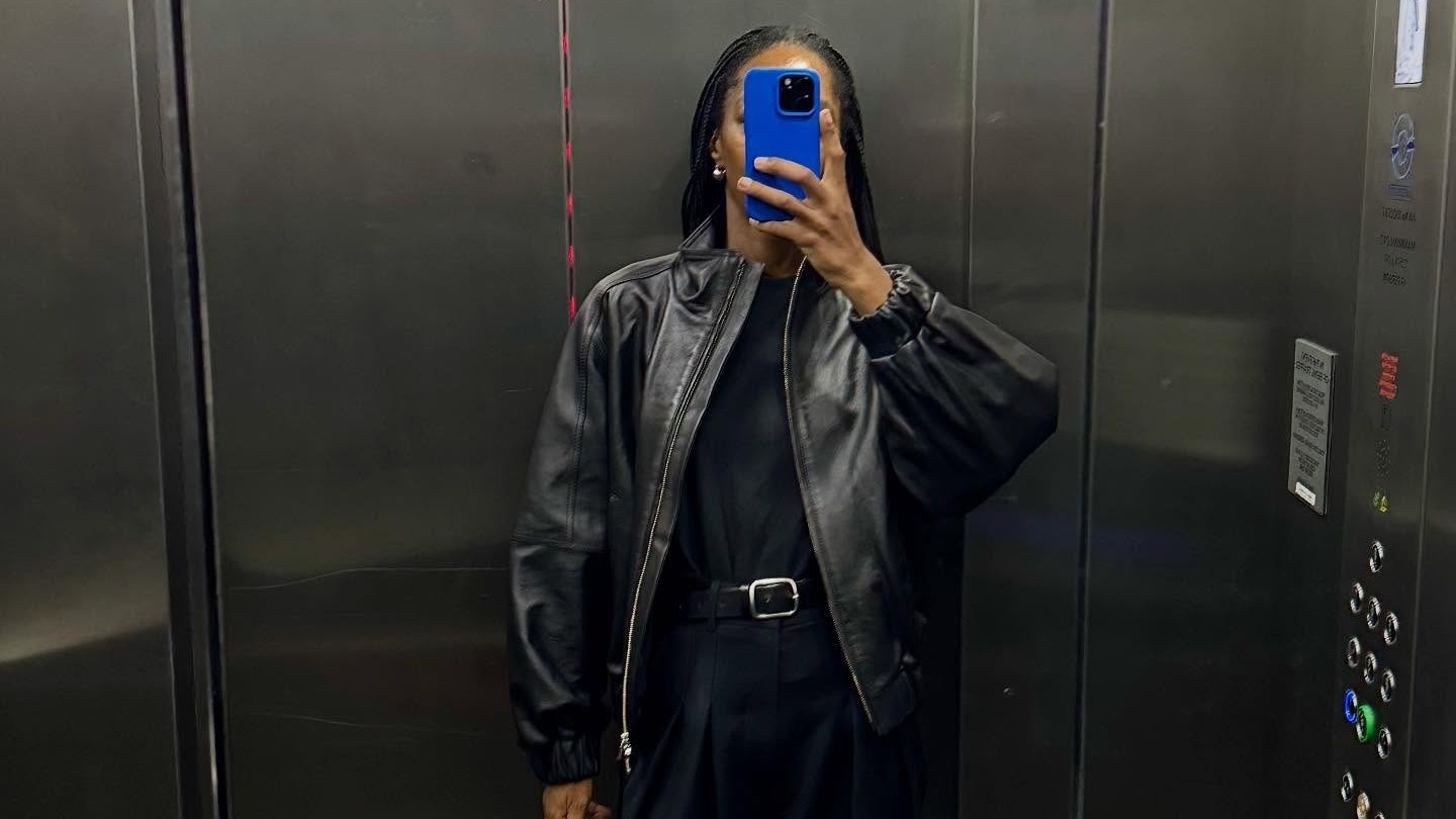 Woman wears a black leather jacket, black shirt and trousers. 