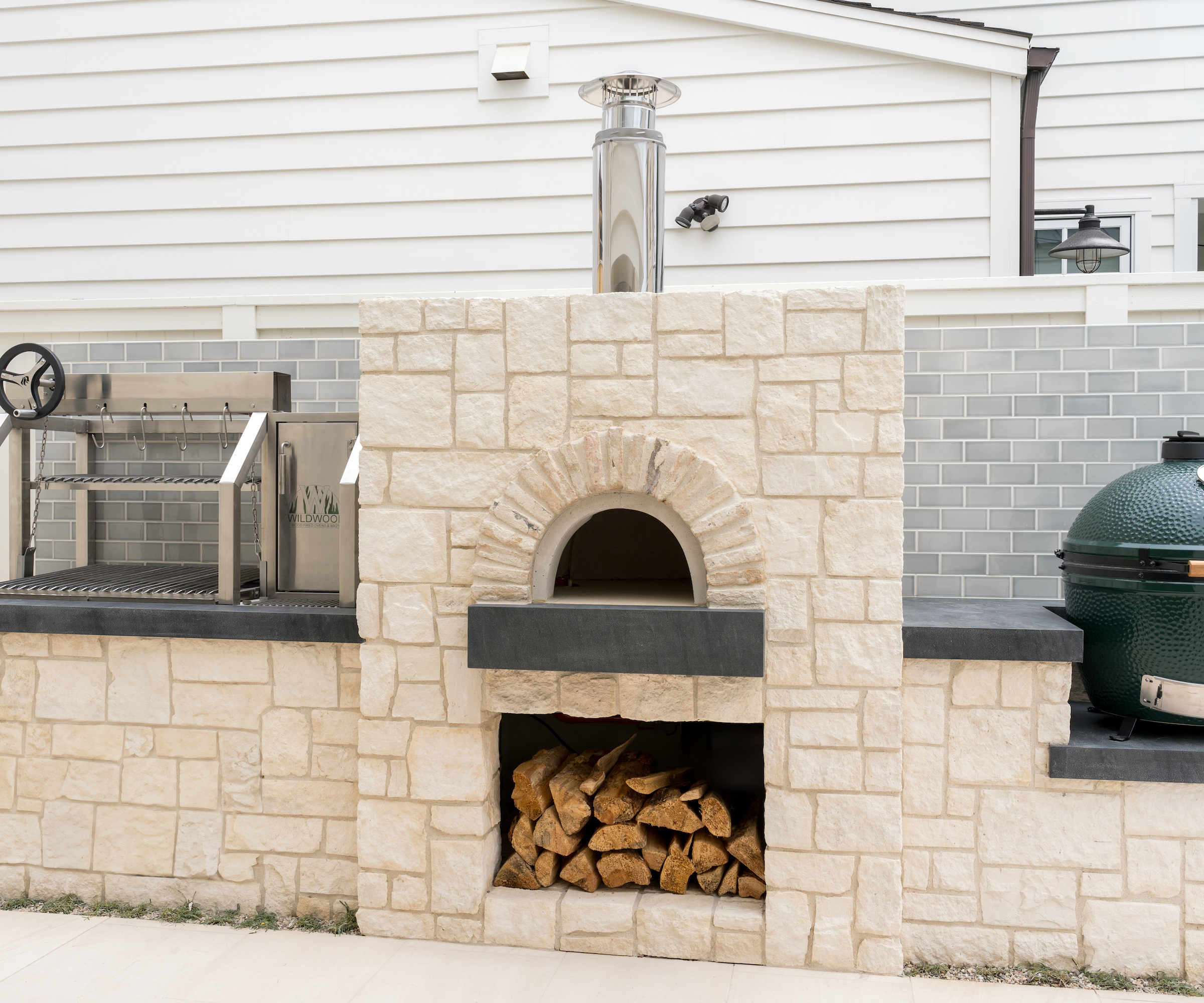 outdoor kitchen with pizza oven, rotisserie and green egg