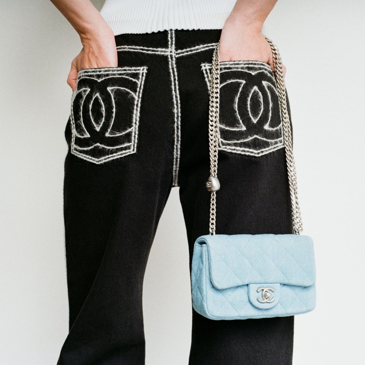 a model wearing chanel trousers and a bag available on bessette