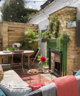 A small outdoor room with fireplace and built in storage
