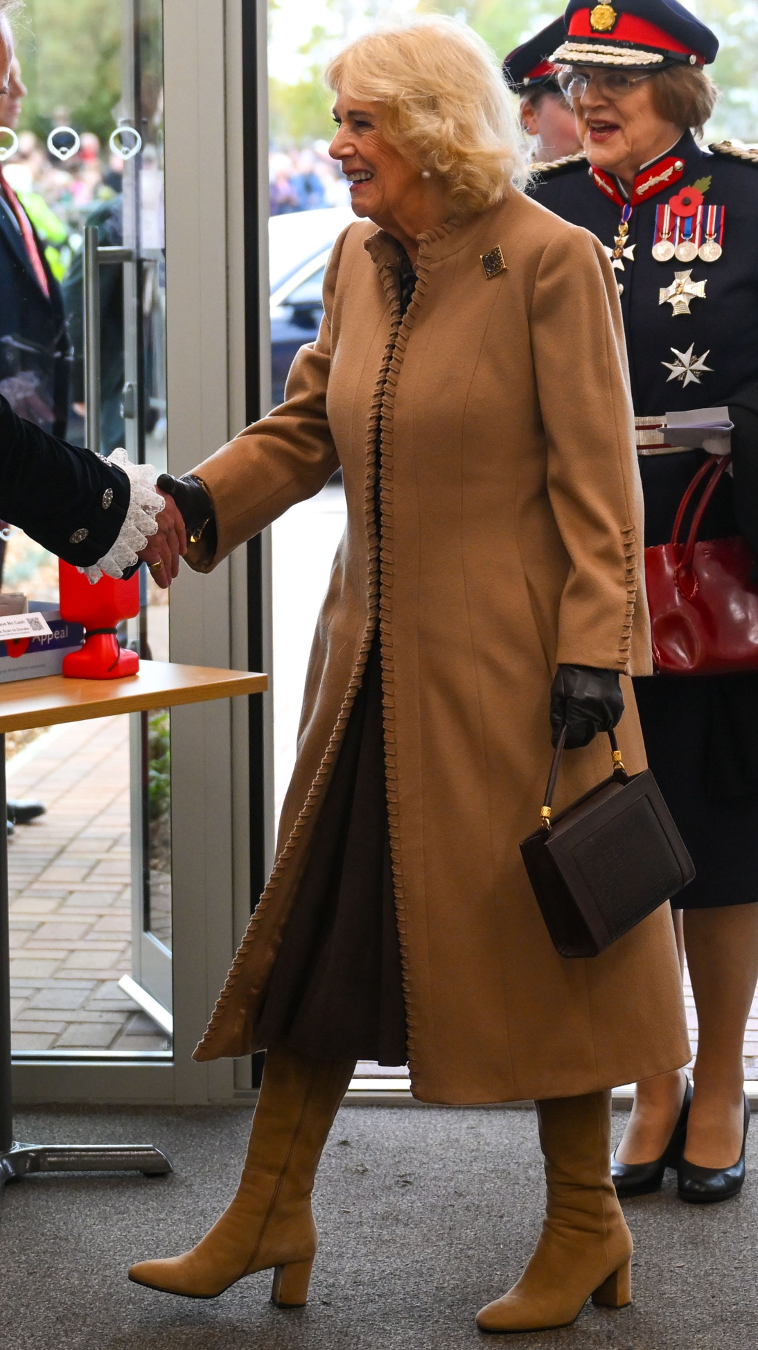 Queen Camilla shakes the hand of a dignitary during her visit to Bromham Community Hub on October 28, 2025