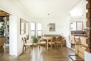 A dining area with wooden mid-century style furniture and banquette seating