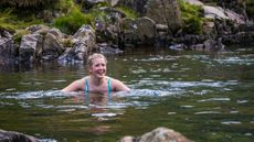 How to get started with wild swimming: Image shows woman swimming outdoors