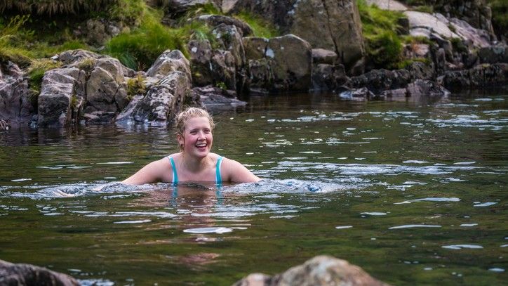 How to get started with wild swimming: Image shows woman swimming outdoors