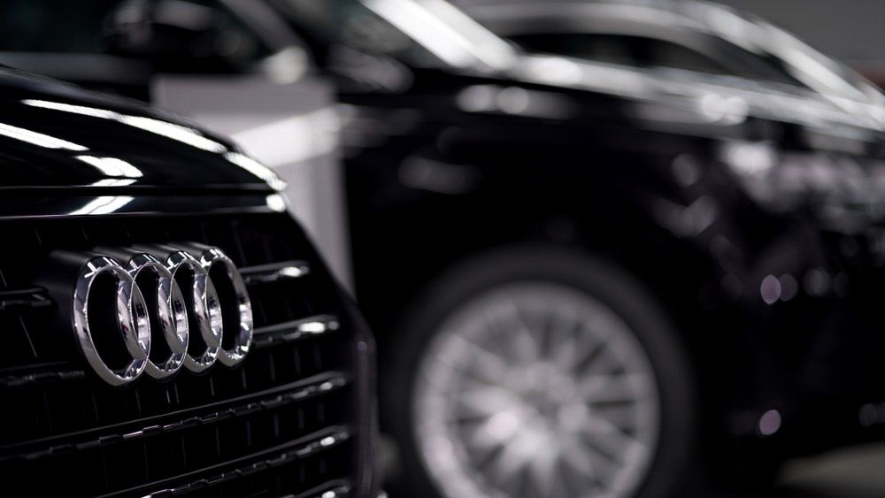 Several Audi vehicles lined up at a dealership.