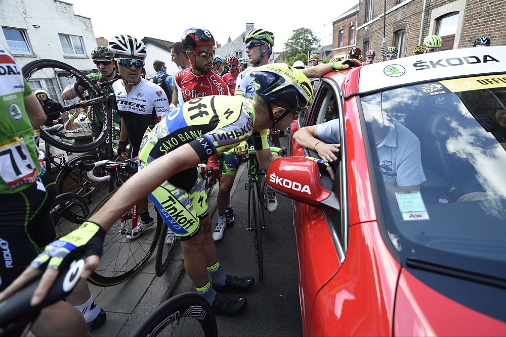 Riders try to figure out why the race was stopped - it was because a massive crash left them without medical support