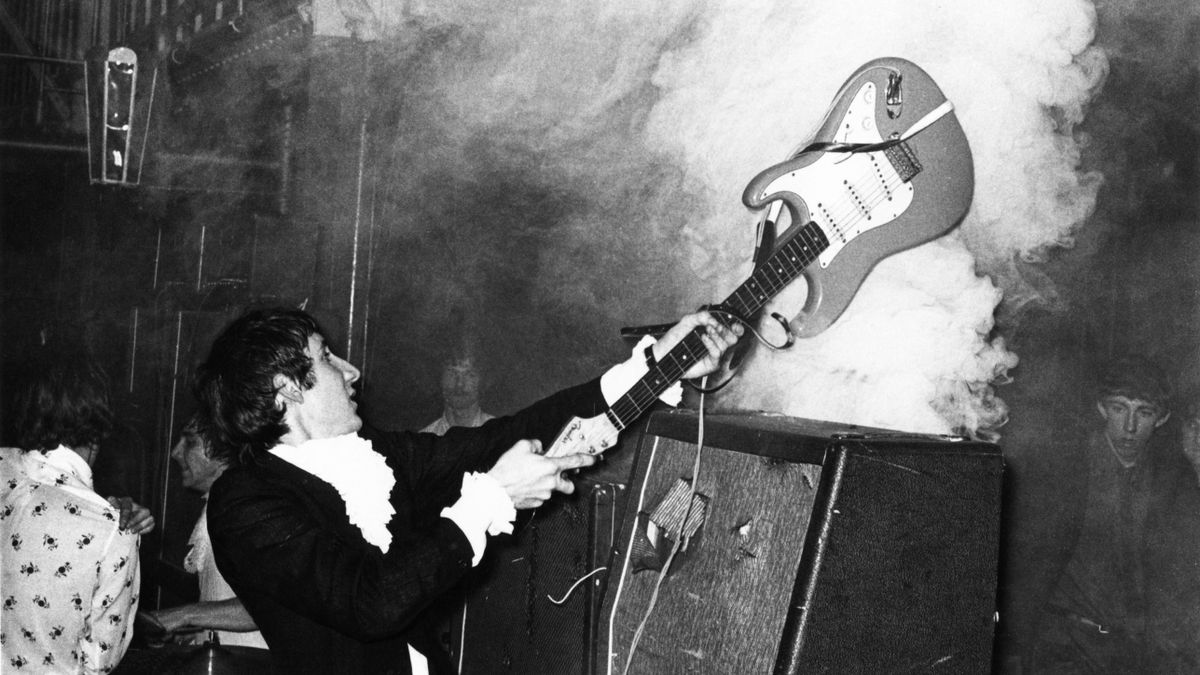 Photo of Pete TOWNSHEND and The Who, Pete Townshend performing live onstage, smashing guitar against amplifier 