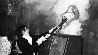 Photo of Pete TOWNSHEND and The Who, Pete Townshend performing live onstage, smashing guitar against amplifier 