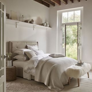 White bedroom with furry ottoman