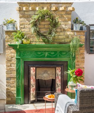 outdoor fireplace painted green with wreath decoration