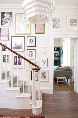 Staircase with carpet runner and gallery wall