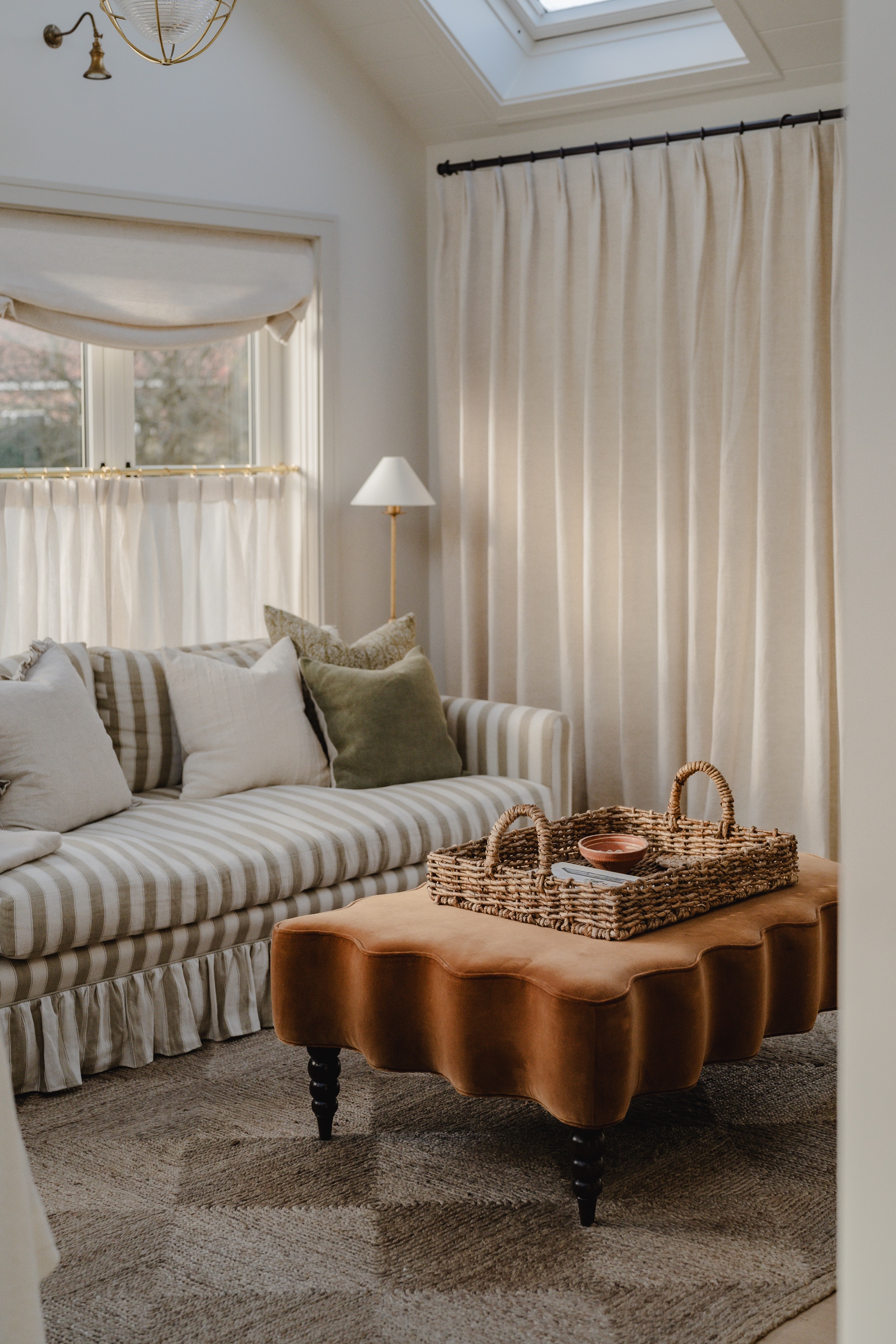Beige living room with striped sofa and ochre ottoman by House Nine