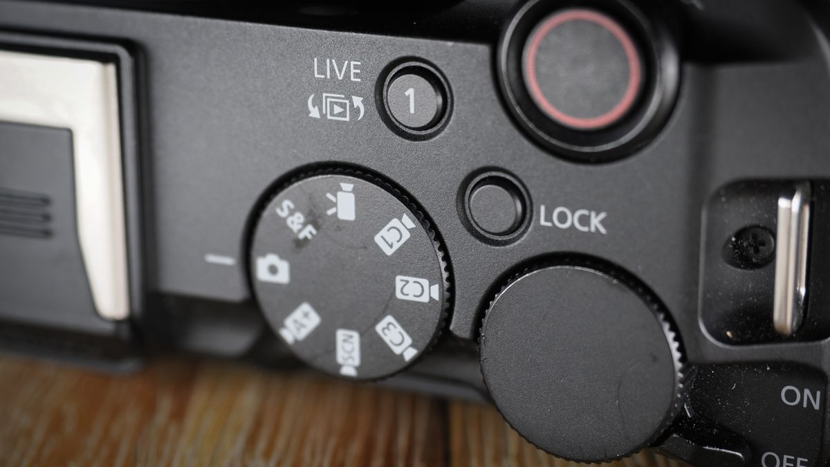 Canon EOS R50 V on a wooden surface, against a dark background