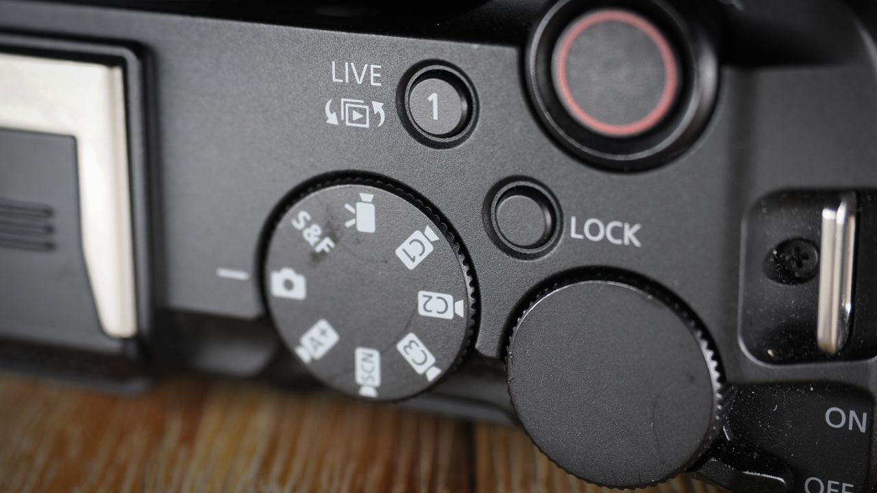 Canon EOS R50 V on a wooden surface, against a dark background