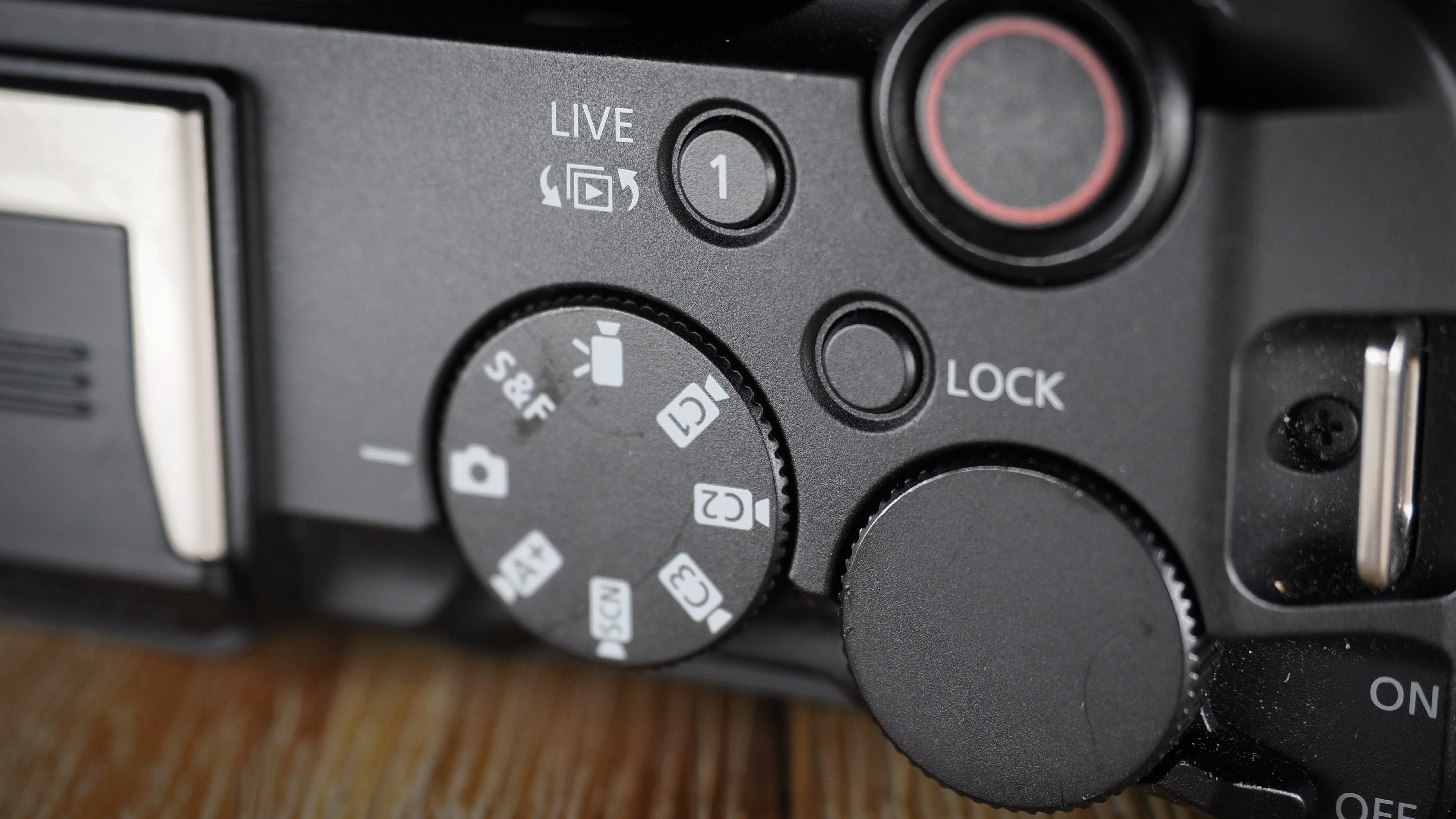 Canon EOS R50 V on a wooden surface, against a dark background