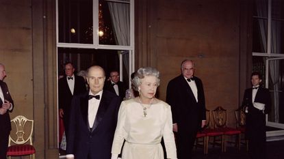 britains queen elizabeth ii leads french president françois mitterrand l, german chancellor helmut kohl r and other participants onto a balcony of buckingham palace following a banquet during the london 17th g7 summit on july 16, 1991 photo by jean loup gautreau afp photo credit should read jean loup gautreauafp via getty images