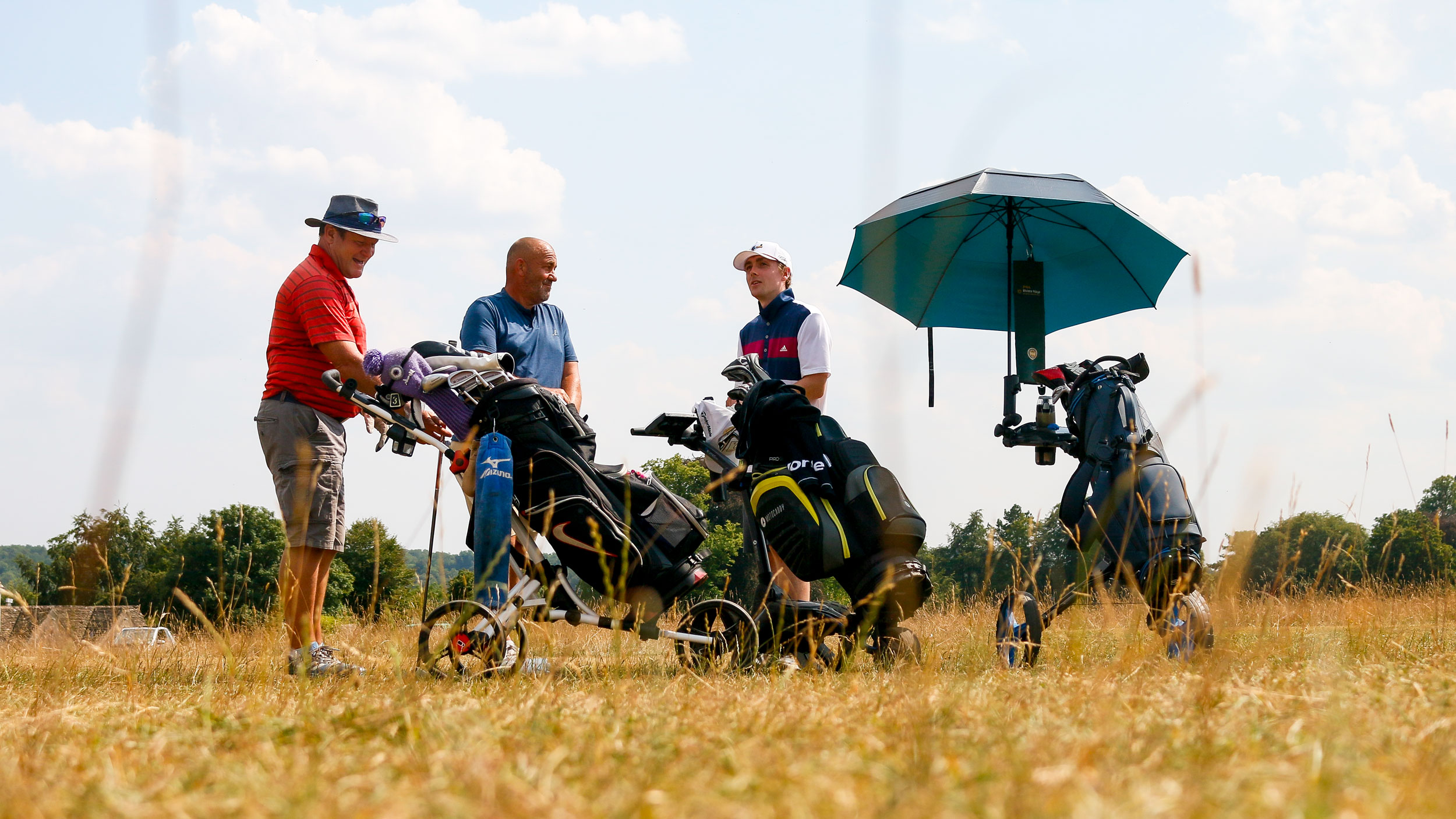 Jonny Leighfield (right) talking with his playing partners at the 2026 iGolf Open event at Minchinhampton