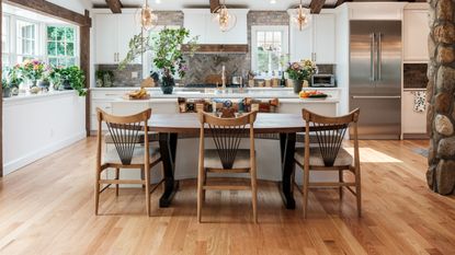 Farmhouse open style kitchen with three spindle back black chairs at the island which are striking statement chairs