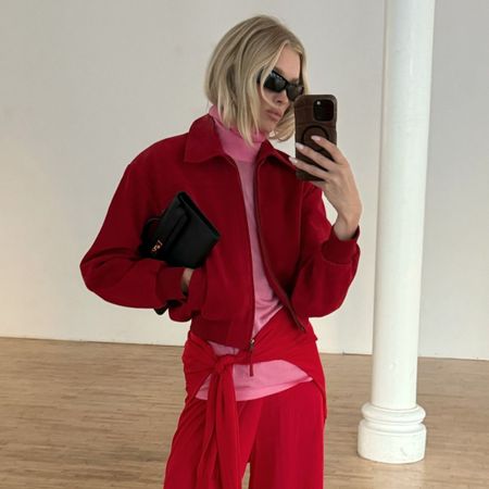 Elsa Hosk taking a mirror selfie in a red jacket and trousers with a blonde disconnected bob hairstyle