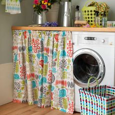 laundry room with tumble dryer covered by curtain