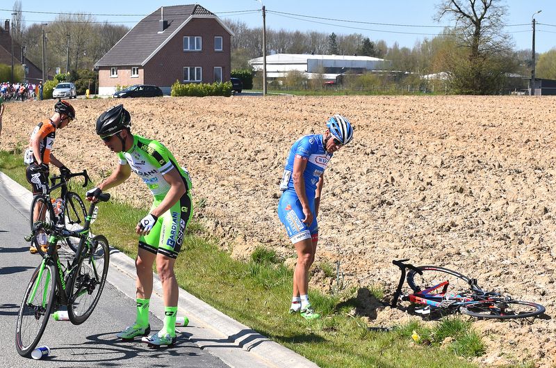 Riders get back on their feet after a crash in the peloton