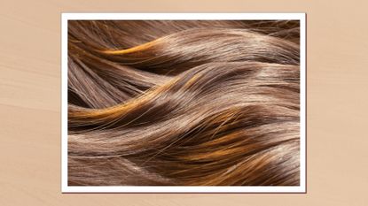 A close up of someone&#039;s long, wavy brunette hair/ in a beige template