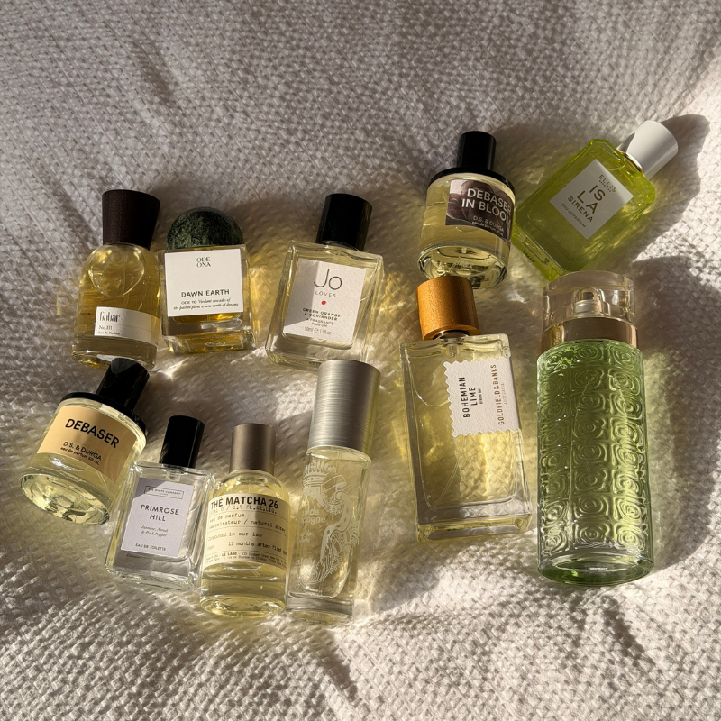 A collection of best green perfumes on a fabric background