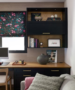 Small home office with black cabinetry and a floral blind