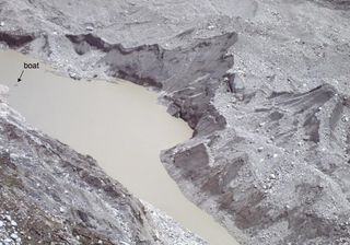 A glacial lake on the Ngozumpa Glacier in Nepal after losing the equivalent of 46 Olympic-sized swimming pools of water. Bare ice walls are visible on the far side of the lake.