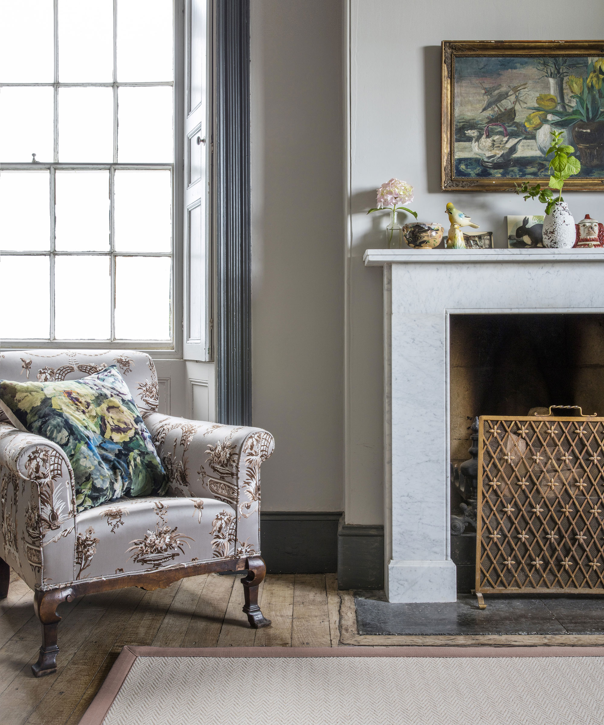 period style living room with marble fireplace and pink jute rug with silk armchair