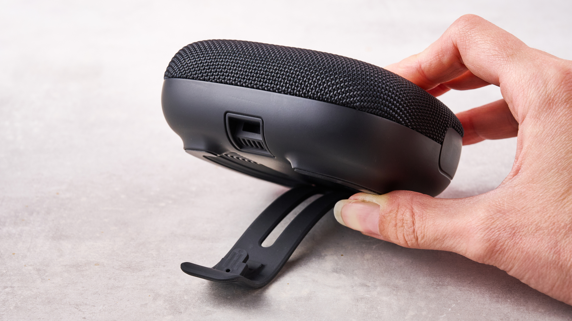 A woman's hand showing the rear clip of the Tribit Stormbox Micro 3.