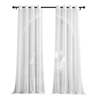 White sheer curtains on a black curtain rail