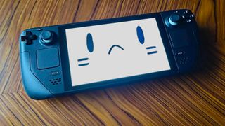 Steam Deck LCD on woodgrain table with sad face on screen.