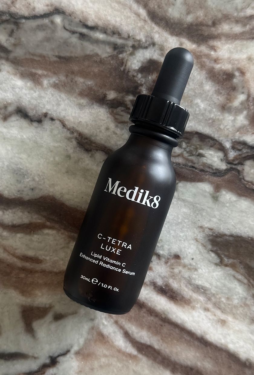 The Medik8 C-Tetra Luxe Serum bottle close up on marble table