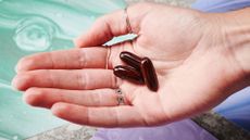 person holding three multivitamin capsules in their hand