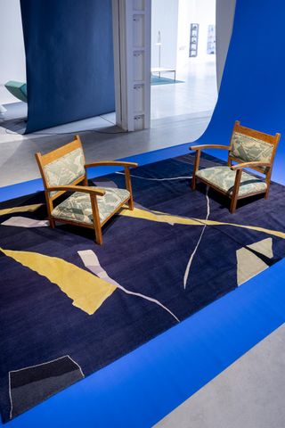 Two low chairs upholstered in green fabric, on blue rug