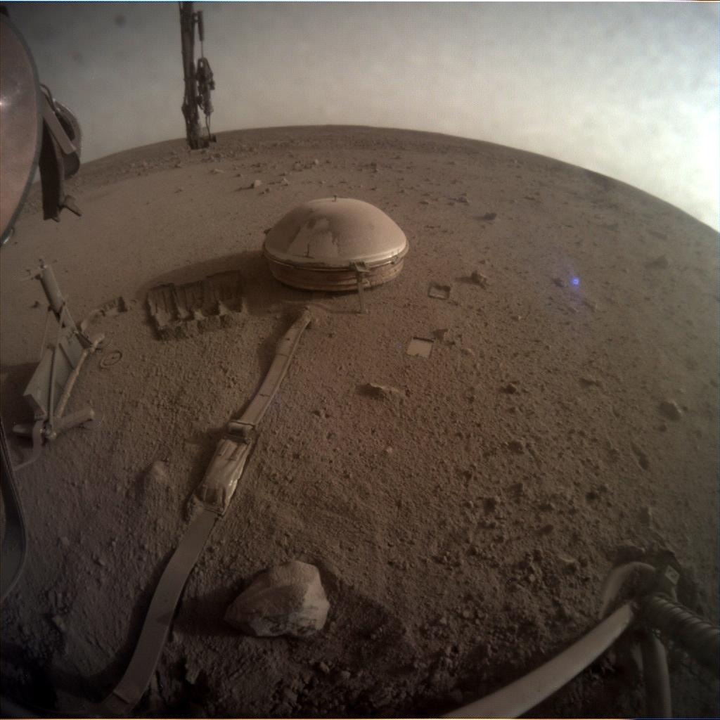 a metallic dome on the surface of a flat, reddish dusty surface