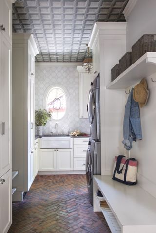 mudroom and laundry room with chevron tiled terracotta floor and decorated ceiling