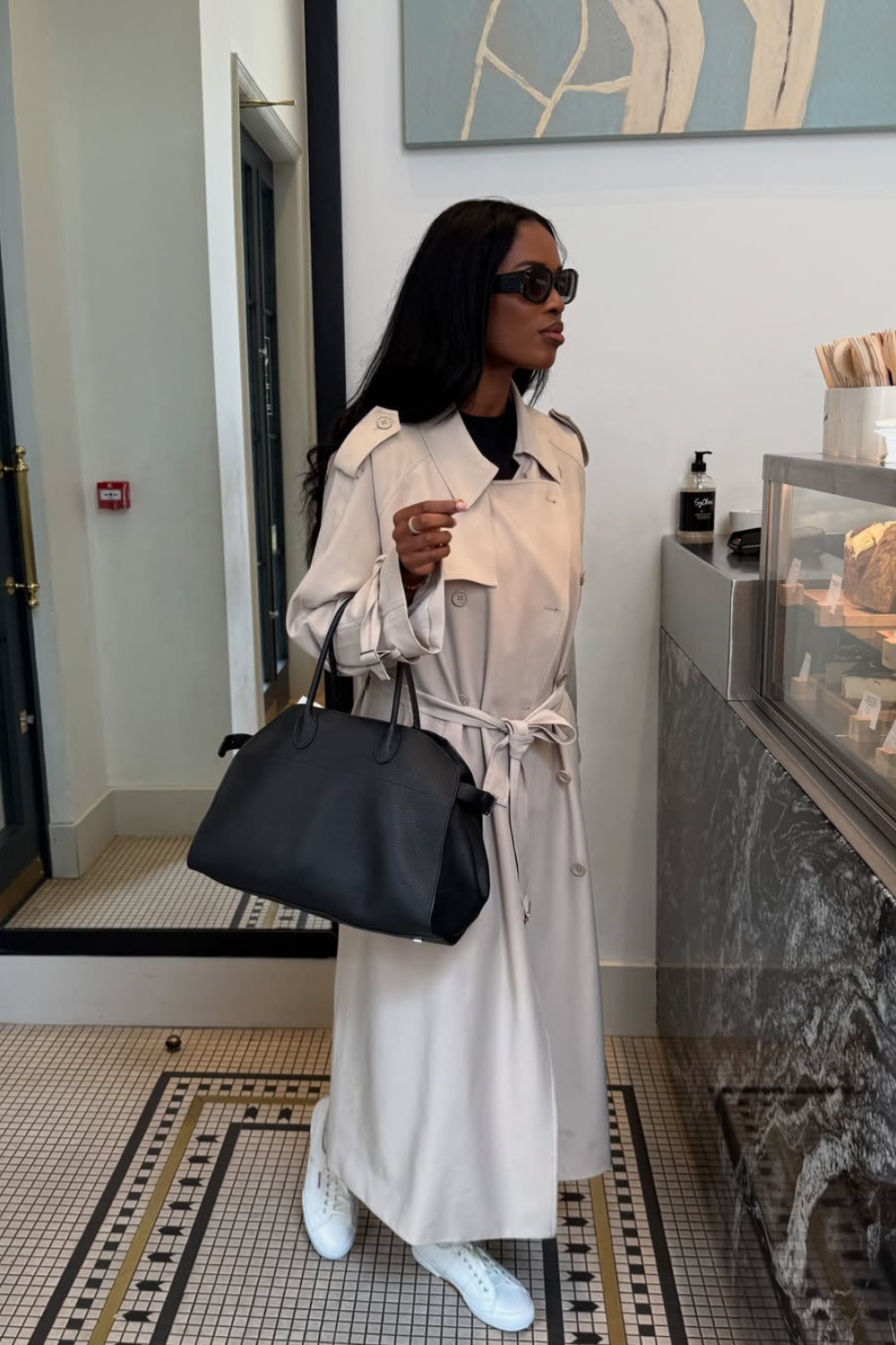 @nlmarilyn wears trench coat, black bag and white trainers