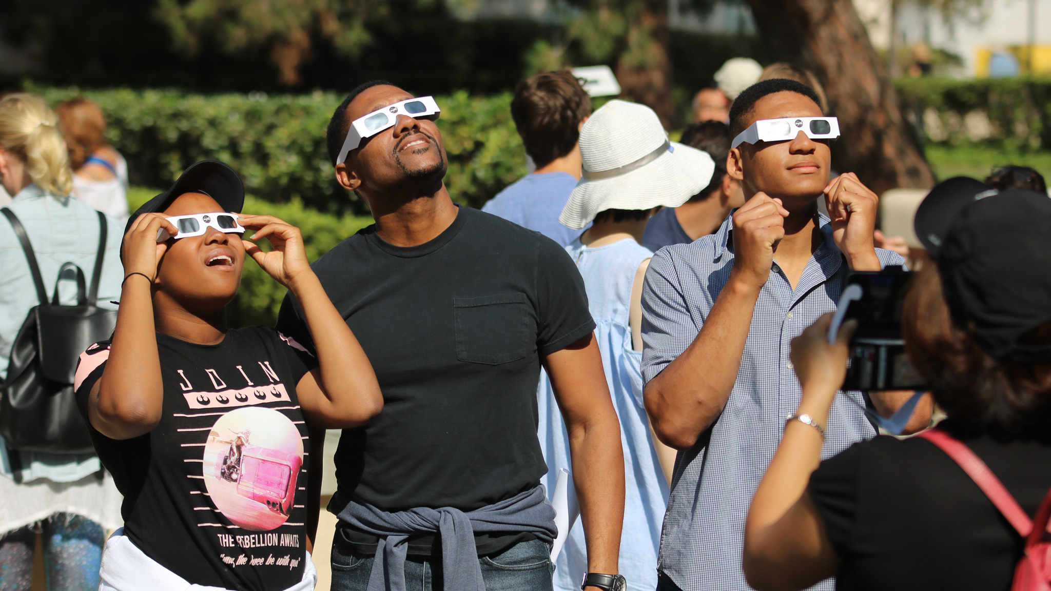 Total Solar Eclipse showing people wearing glasses and looking at the eclipse