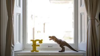 Picture of a window sill with a decorate letter F and t-rex dinosaur toy