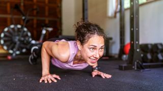 Woman performs push-up in garage gym
