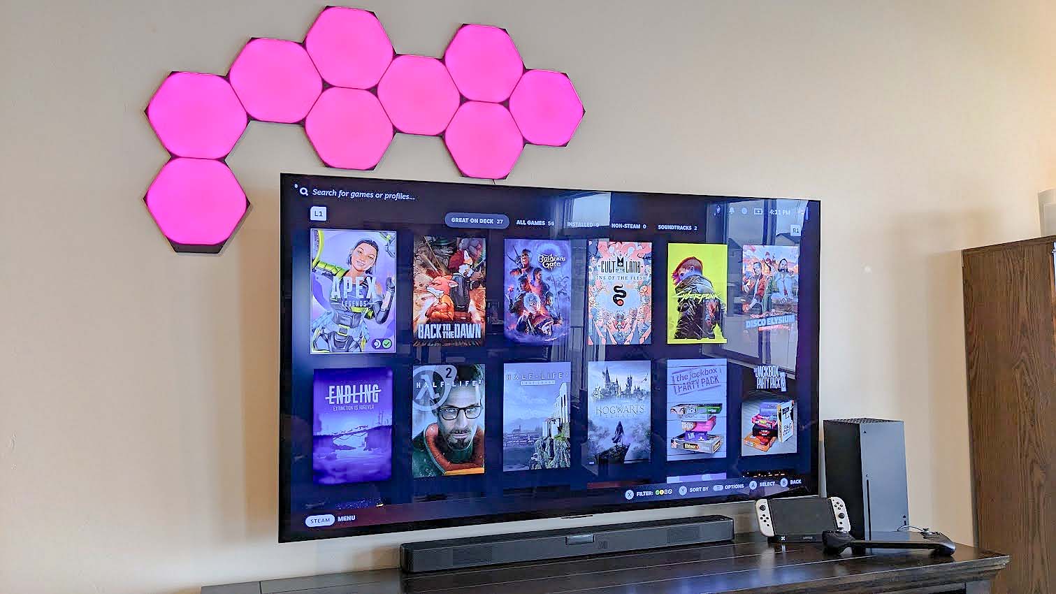 Nanoleaf Shapes Ultra Black Hexagons over TV pink.