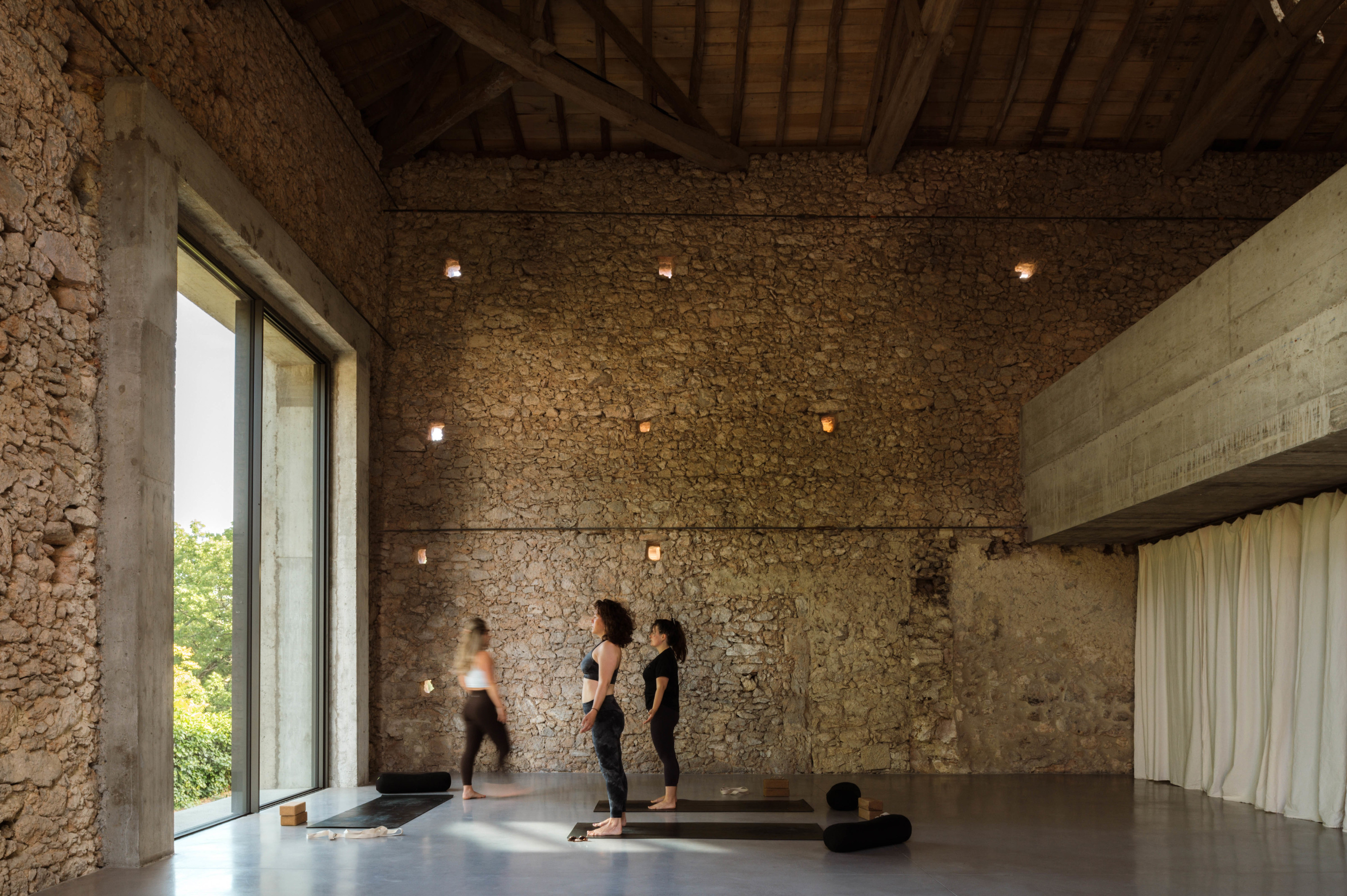 The mezzanine at right appears suspended between the original stone walls