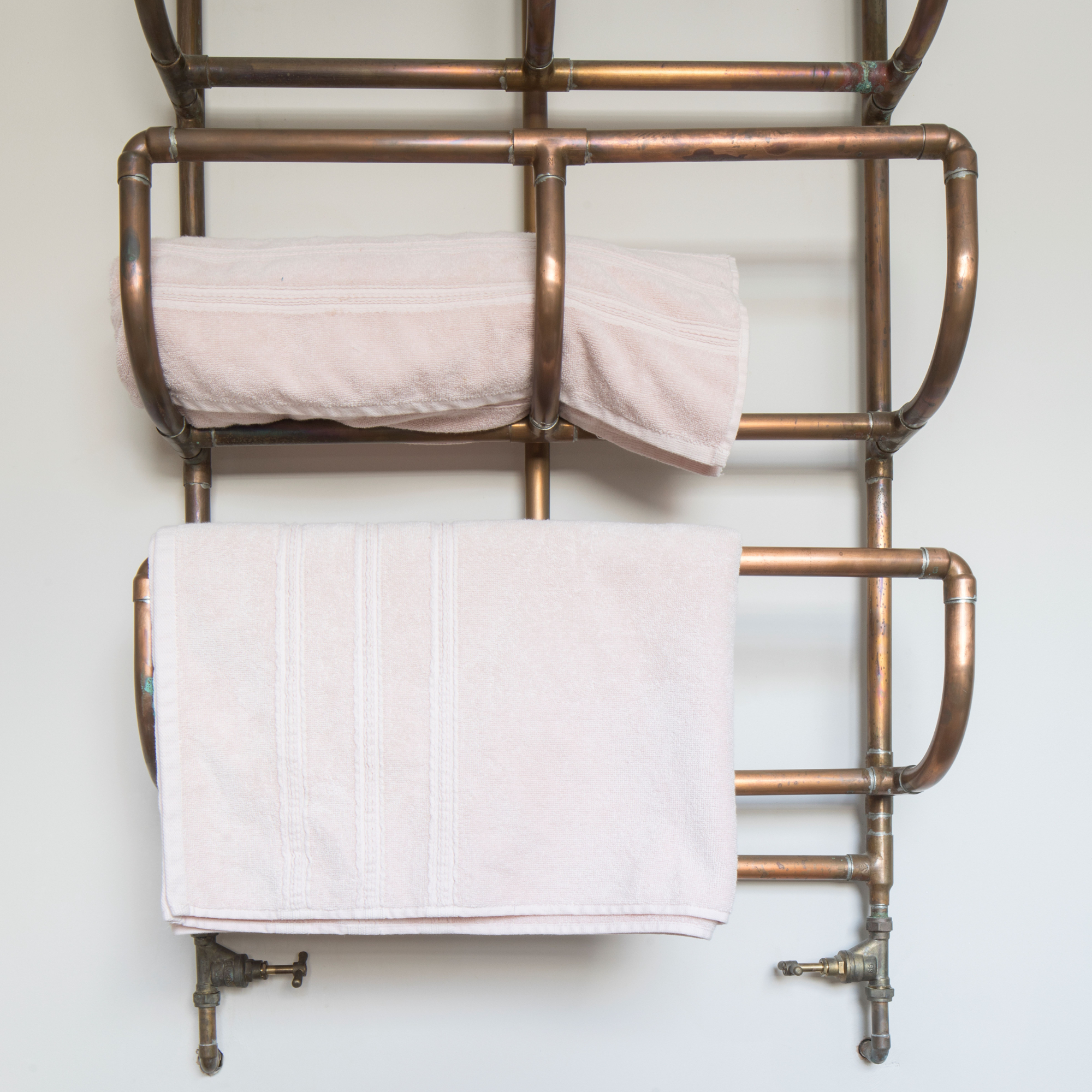 Gold metallic towel rails with towels hanging and stored