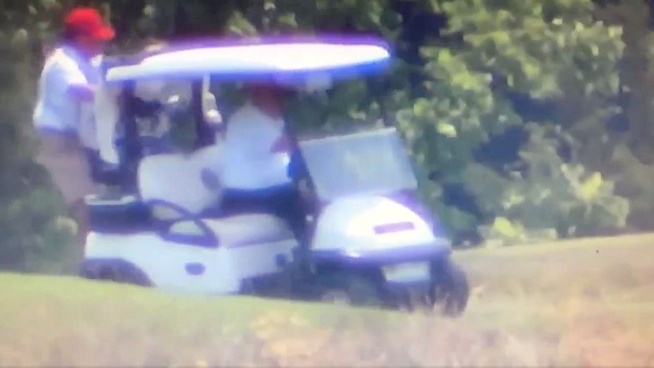 Trump driving golf cart with caddy