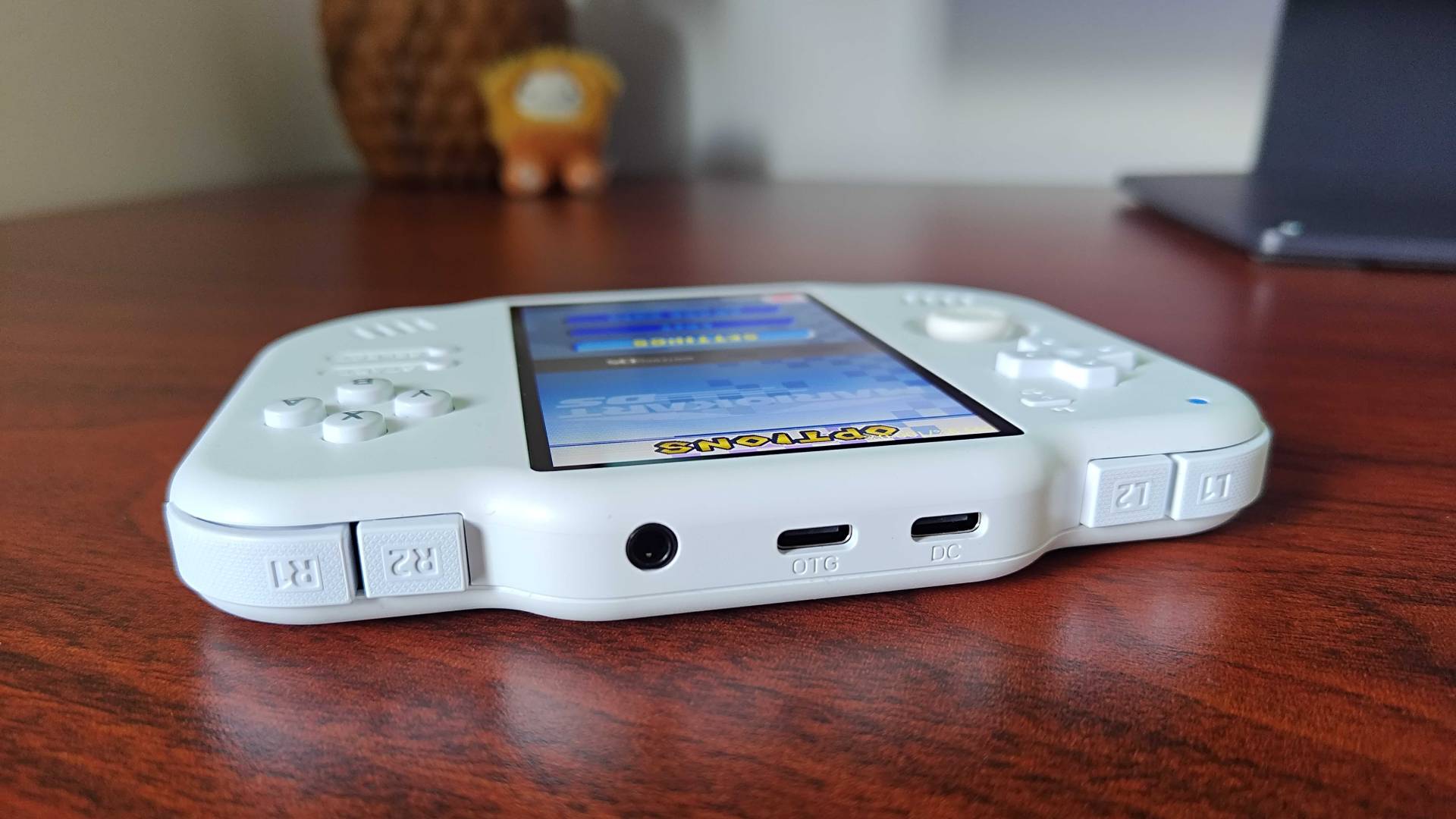 Close up of MagicX Zero 40 top ports and shoulder buttons sitting on woodgrain desk.